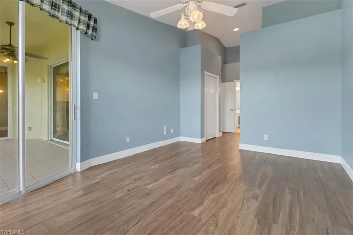 Main room featuring baseboards, ceiling fan, wood finished floors, recessed lighting, and a high ceiling