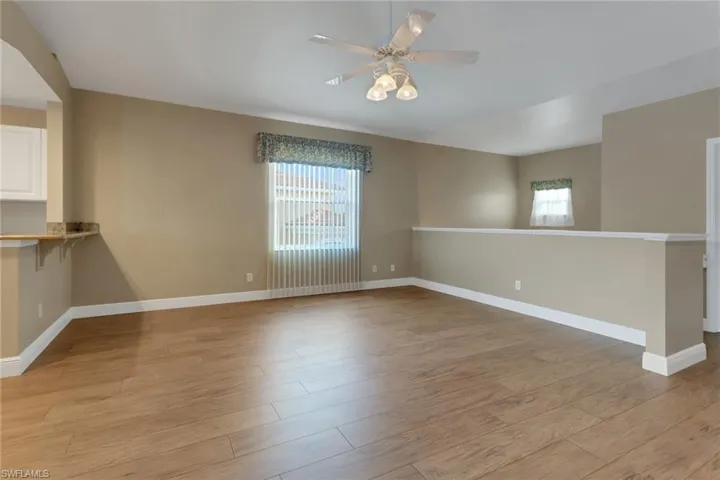 Bright & airy room with light wood-style floors, ceiling fan, and lots of natural light