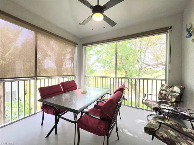 Sunroom featuring ceiling fan, outdoor dining area, and a balcony