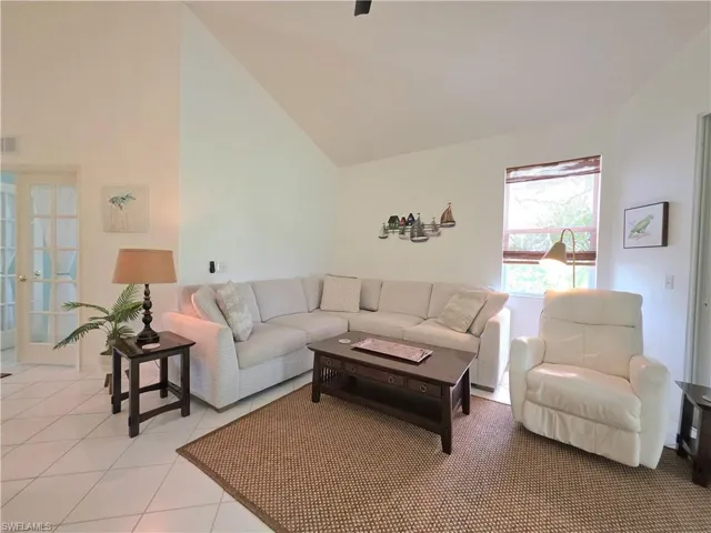Tiled living area with vaulted ceiling and french doors