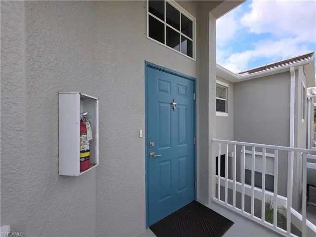Doorway to property with stucco siding