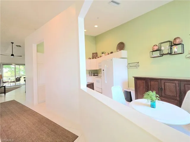 Hall with light tile patterned floors and recessed lighting