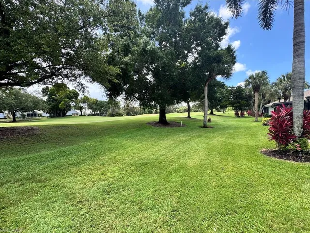 Expansive green lawn with mature trees and tropical plantings