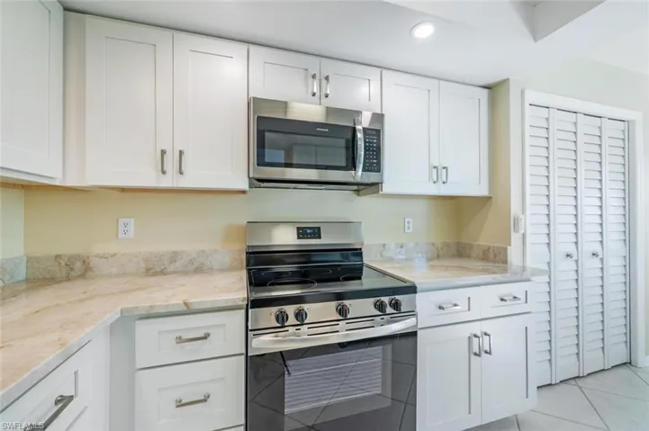 Taj Mahal Quartzite Countertop, Backsplash, and a Large Pantry to Right of Cabinets