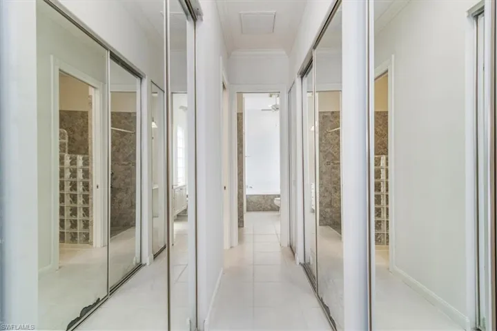 Corridor featuring ornamental molding and light tile patterned flooring