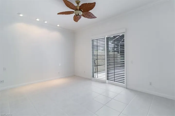 Tiled spare room featuring ornamental molding and ceiling fan