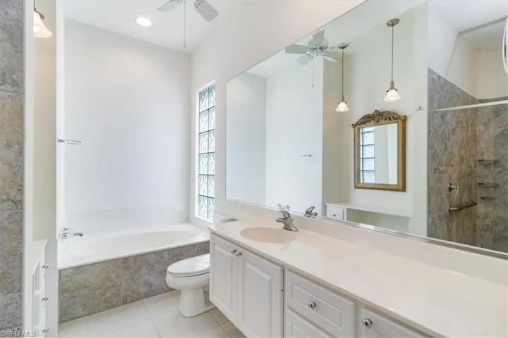 Bathroom featuring vanity, tile patterned floors, a healthy amount of sunlight, and ceiling fan