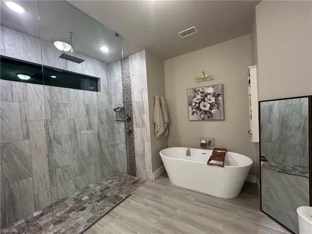 Bathroom with a walk in shower and a freestanding bath
