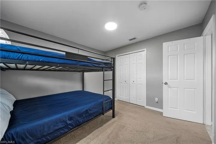 Carpeted bedroom with a closet