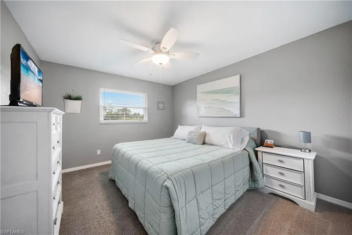 Bedroom featuring dark carpet and ceiling fan