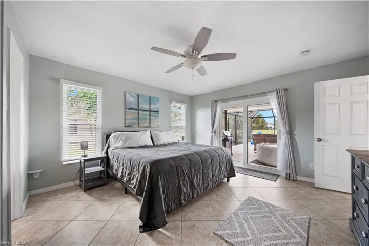 Bedroom featuring light tile patterned floors, access to exterior, and ceiling fan