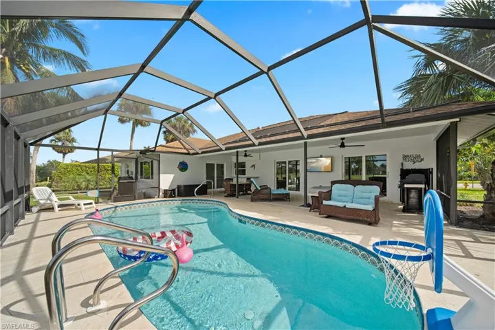 View of swimming pool with ceiling fan, outdoor lounge area, a patio area, and glass enclosure