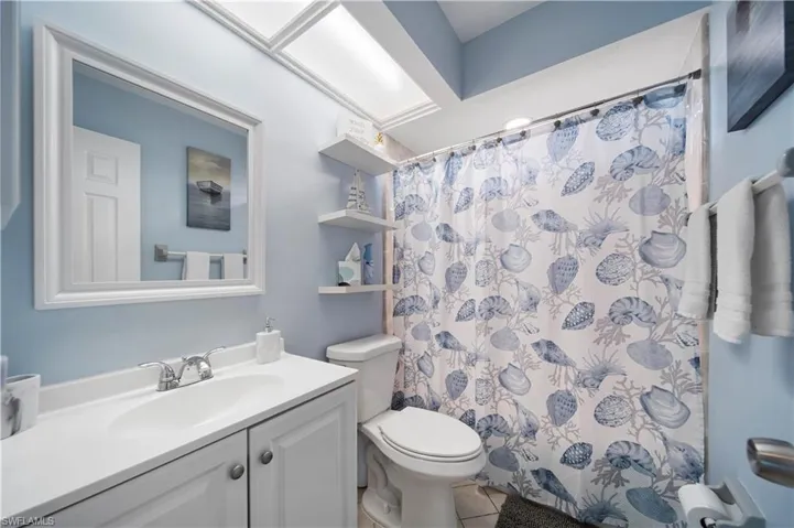 Bathroom with vanity, toilet, and a shower with shower curtain