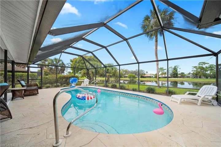 View of swimming pool featuring a lanai, a patio area, and a water view