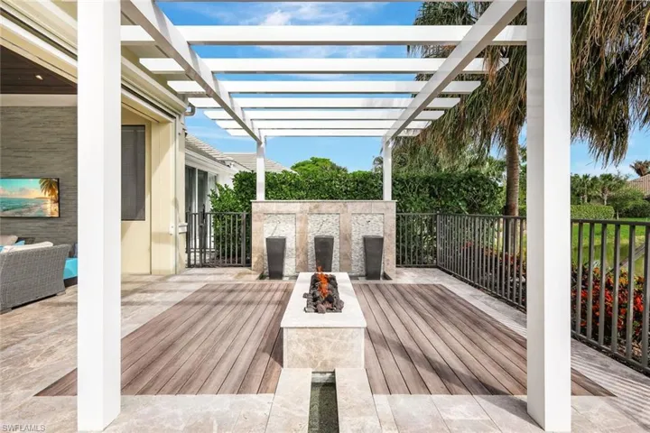 Wooden terrace with a pergola and an outdoor living space