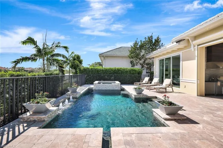 View of swimming pool featuring an in ground hot tub, pool water feature, and a patio