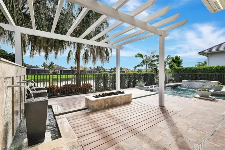 Wooden deck featuring a pool with hot tub, a water view, and a pergola