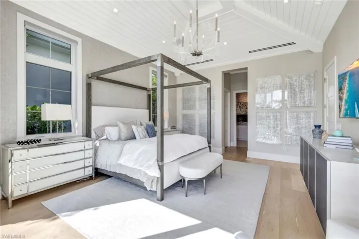 Bedroom with wooden ceiling, light hardwood / wood-style flooring, beamed ceiling, high vaulted ceiling, and a chandelier