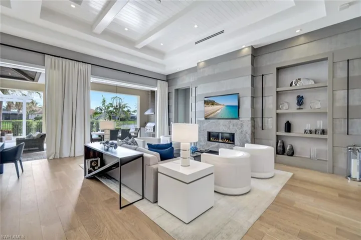 Living room featuring wood ceiling, built in shelves, beam ceiling, a fireplace, and light hardwood / wood-style floors