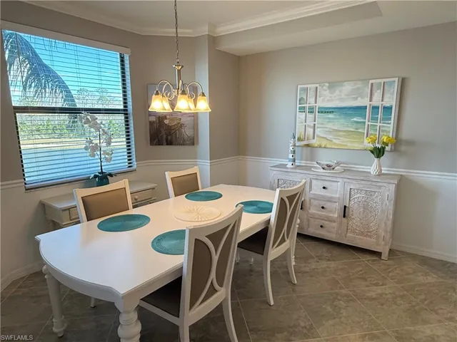 Dining area featuring suspended lighting and ornamental molding