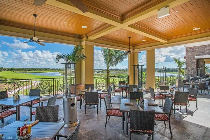 View of patio / terrace featuring a water view, outdoor dining area, ceiling fan, and golf course view