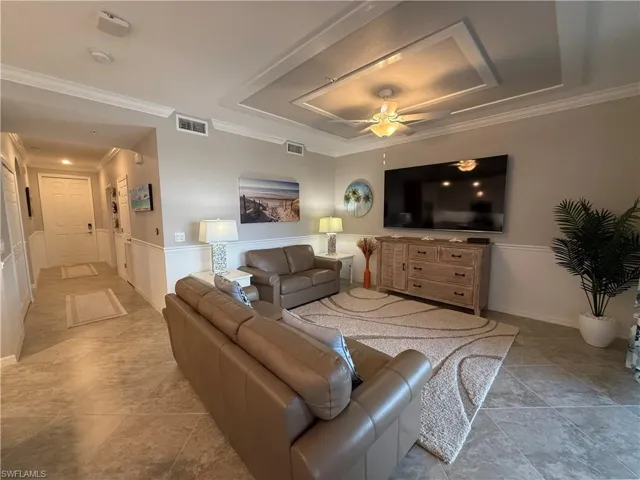 Living area featuring ceiling fan and ornamental molding