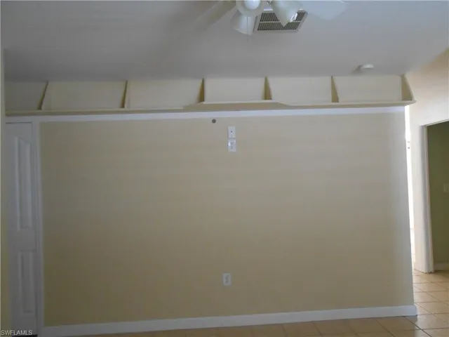 Unfurnished room with a ceiling fan and light tile patterned floors