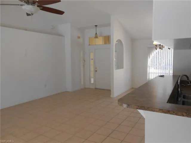 Entryway featuring ceiling fan, vaulted ceiling, and light tile patterned floors