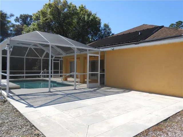 Swimming pool with a patio, a sunroom, and a lanai