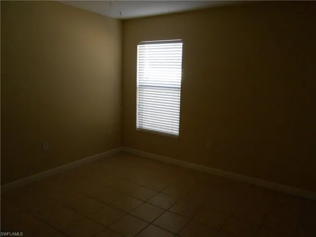 Spare room featuring baseboards and tile patterned floors