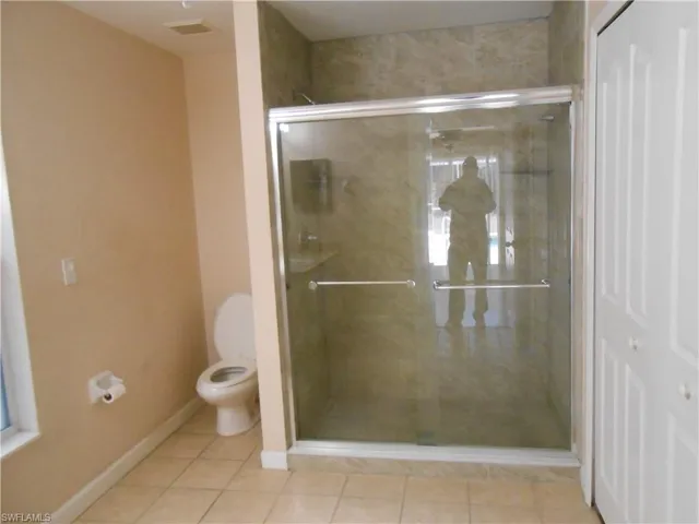 Full bathroom featuring tile patterned floors and a shower stall