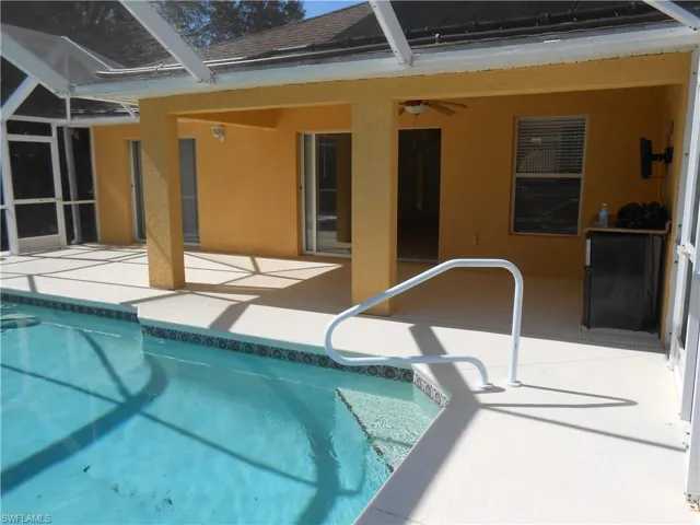Swimming pool with a patio area, a lanai, and a sunroom