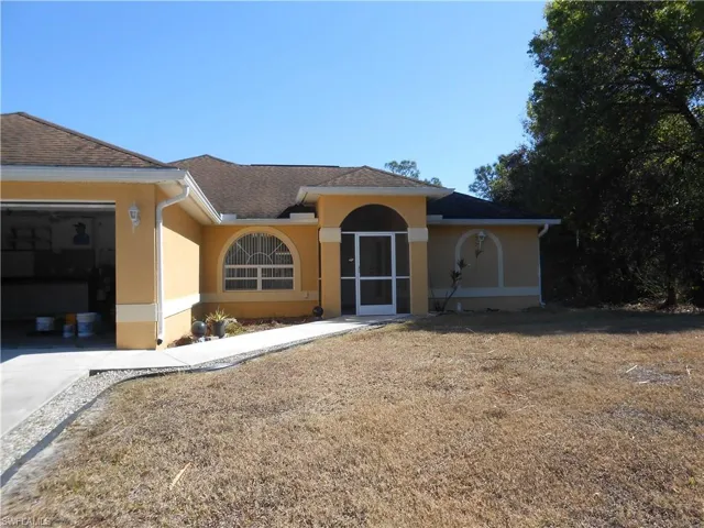 View of front of home with stucco siding, a garage, roof with shingles, and concrete driveway