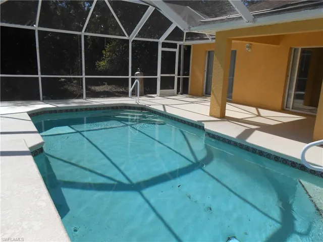 Swimming pool featuring a lanai, a patio, and a sunroom