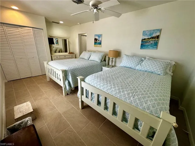 Bedroom featuring a closet, ceiling fan, and tile patterned floors
