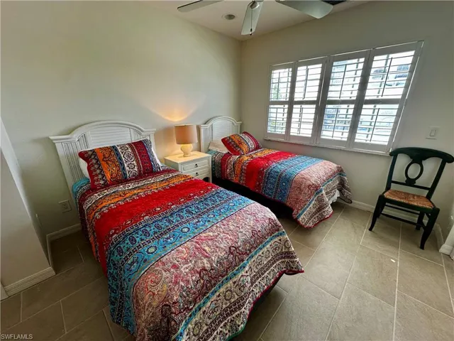 Bedroom with ceiling fan and light tile patterned flooring