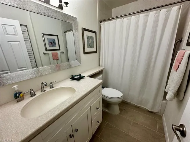 Full bathroom featuring vanity and dark tile patterned flooring