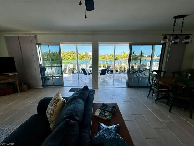 Living area with healthy amount of natural light, a water view, and a ceiling fan