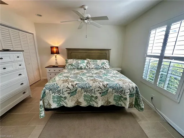 Bedroom with a ceiling fan, a closet, and light tile patterned floors
