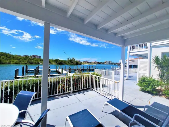 View of patio with a dock and a water view