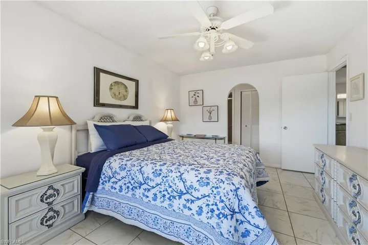Bedroom with light marble finish floors, a ceiling fan, and a closet