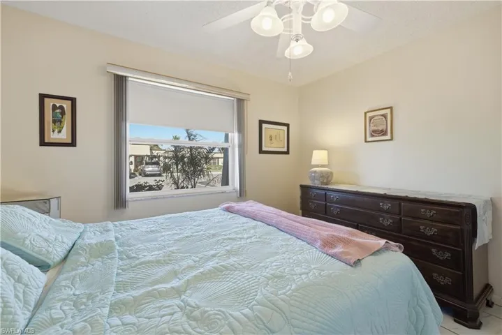 Bedroom with a ceiling fan and a textured ceiling