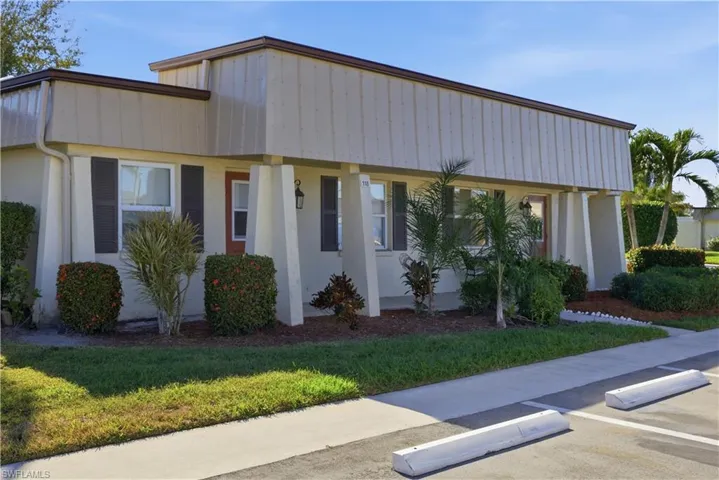 View of front of home featuring a porch, stucco siding, and a front yard