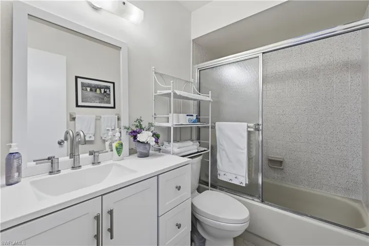 Full bath featuring vanity and combined bath / shower with glass door