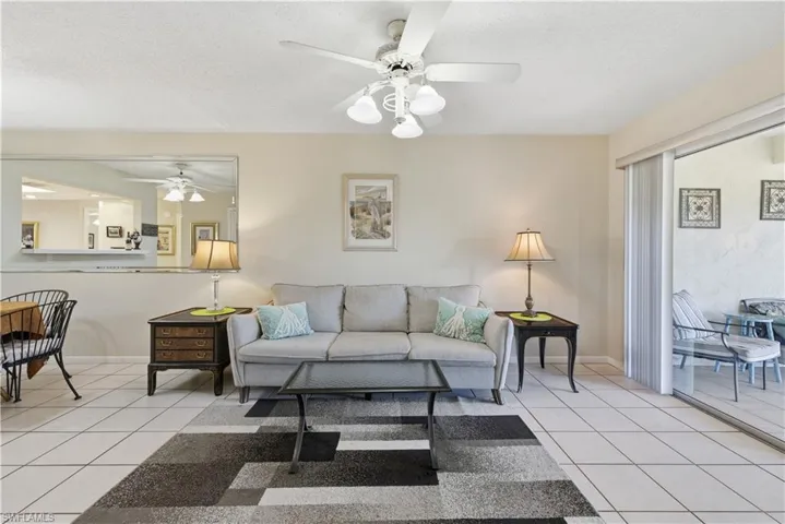 Living room with light tile patterned flooring, a textured ceiling, and a ceiling fan