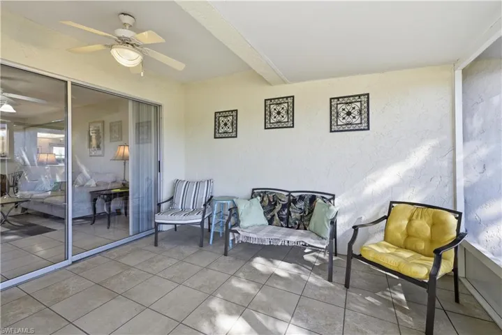 Sunroom / solarium featuring a ceiling fan, beamed ceiling, and a patio area