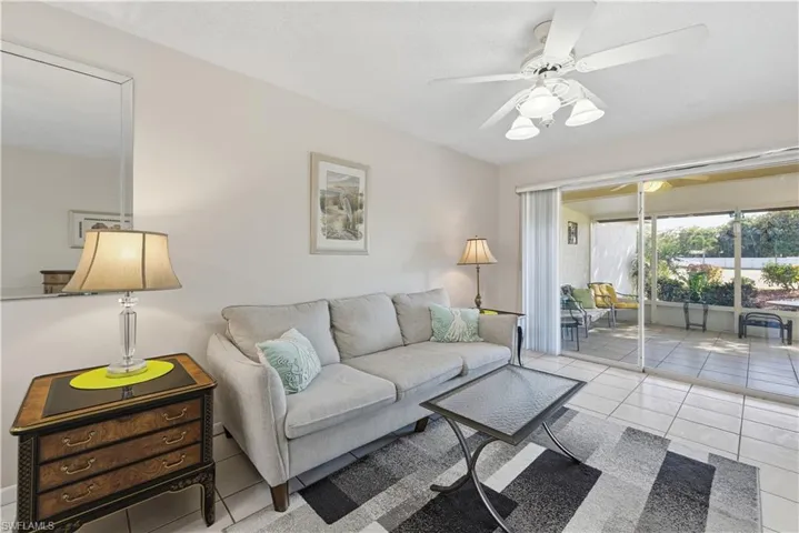 Living room with ceiling fan and tile patterned floors