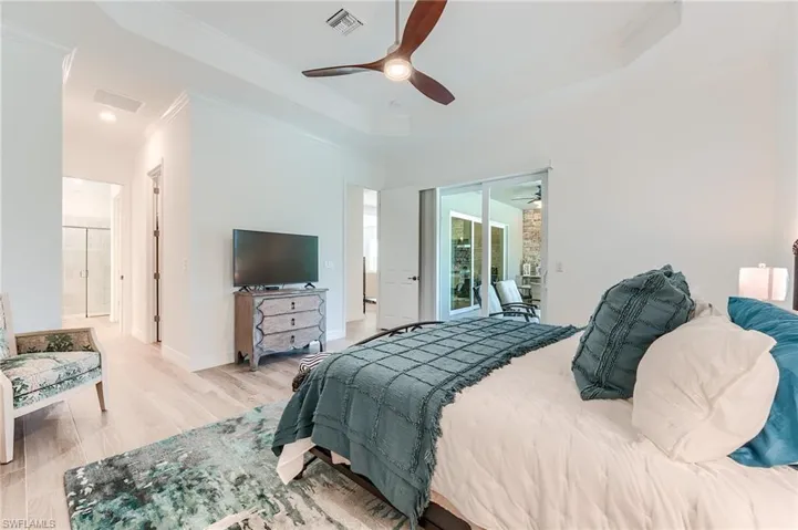 Bedroom with access to exterior, ensuite bathroom, ceiling fan, crown molding, and light hardwood / wood-style floors
