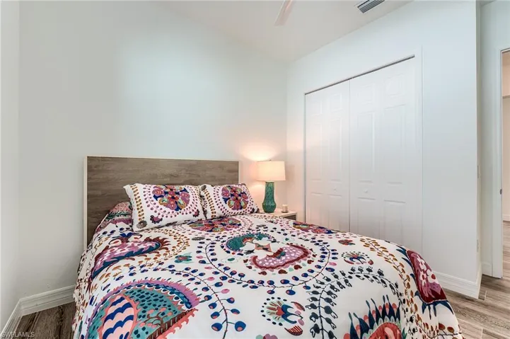 Bedroom with a closet, light hardwood / wood-style flooring, and ceiling fan