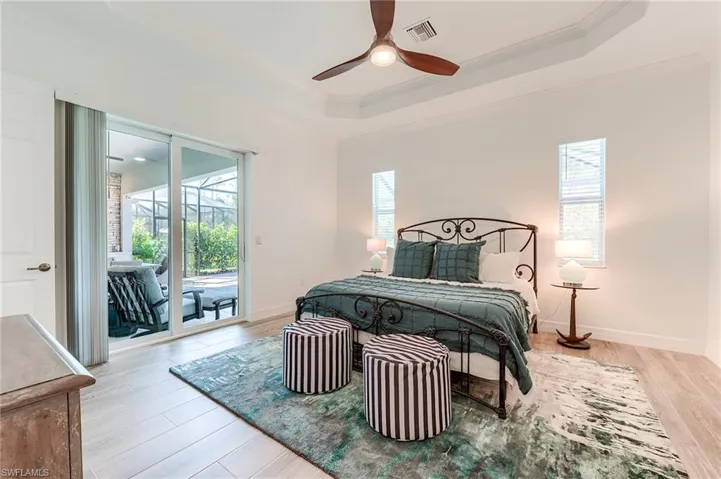 Bedroom featuring multiple windows, light hardwood / wood-style floors, and ornamental molding
